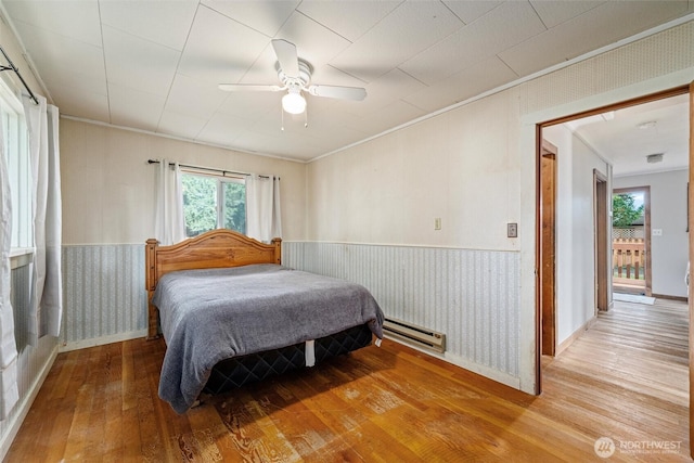 2991 Main St, Custer, WA 98240 - bedroom featuring a baseboard radiator, wood-type flooring, a wainscoted wall, ceiling fan, and ornamental molding