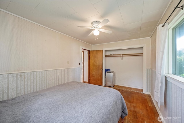 2991 Main St, Custer, WA 98240 - bedroom with wood finished floors, wallpapered walls, a closet, a ceiling fan, and wainscoting