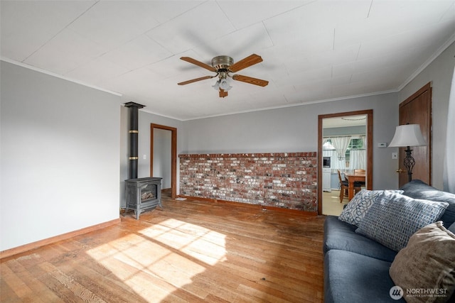 2991 Main St, Custer, WA 98240 - living room with light wood-style floors, ceiling fan, crown molding, and a wood stove