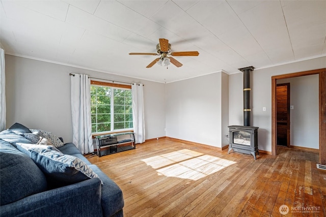 2991 Main St, Custer, WA 98240 - living area featuring hardwood / wood-style floors, a ceiling fan, a wood stove, and crown molding
