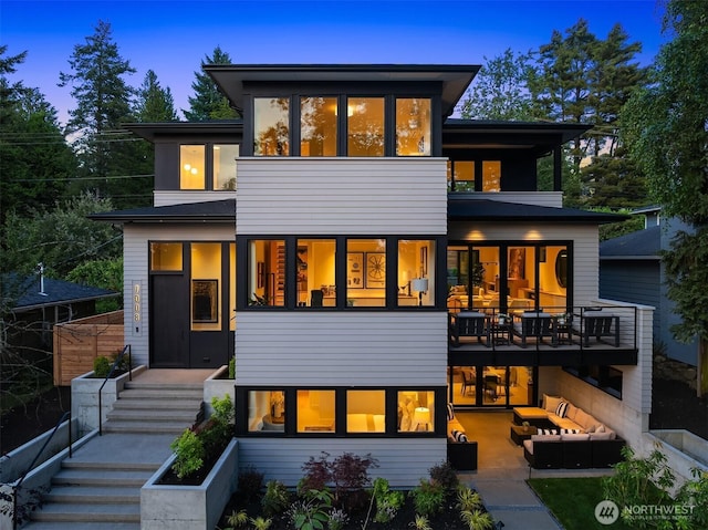 7008 29th Ave NE, Seattle, WA 98115 - back of property at dusk featuring an outdoor living space and stairs