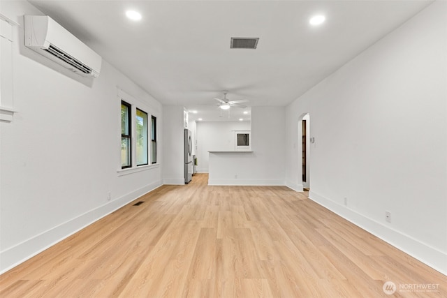 1816 S Adams St, Tacoma, WA 98405 - unfurnished living room featuring a wall unit AC, recessed lighting, a ceiling fan, arched walkways, and light wood finished floors