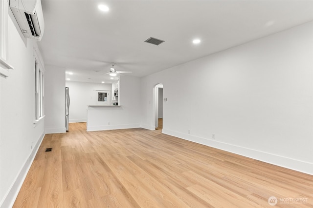 1816 S Adams St, Tacoma, WA 98405 - unfurnished living room featuring a wall mounted air conditioner, arched walkways, recessed lighting, ceiling fan, and light wood-style floors