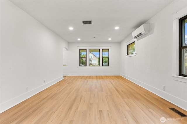 1816 S Adams St, Tacoma, WA 98405 - spare room featuring an AC wall unit, recessed lighting, light wood-type flooring, and arched walkways
