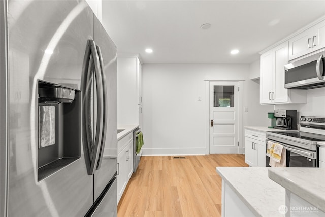 1816 S Adams St, Tacoma, WA 98405 - kitchen with appliances with stainless steel finishes, light wood finished floors, white cabinetry, recessed lighting, and light stone counters