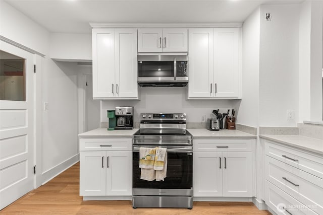 1816 S Adams St, Tacoma, WA 98405 - kitchen with stainless steel appliances, white cabinetry, light countertops, and light wood-style floors