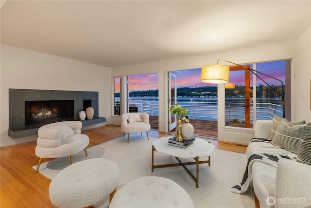5438 E Mercer Way, Mercer Island, WA 98040 - living area featuring wood finished floors, a water view, and a warm lit fireplace