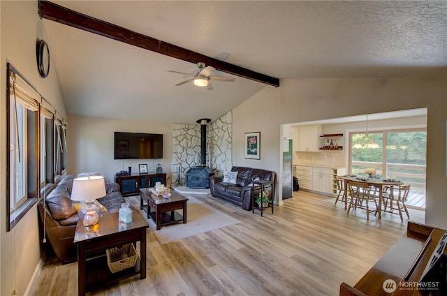 27521 U St, Ocean Park, WA 98640 - living room featuring light wood-style flooring, a wood stove, ceiling fan, and a textured ceiling