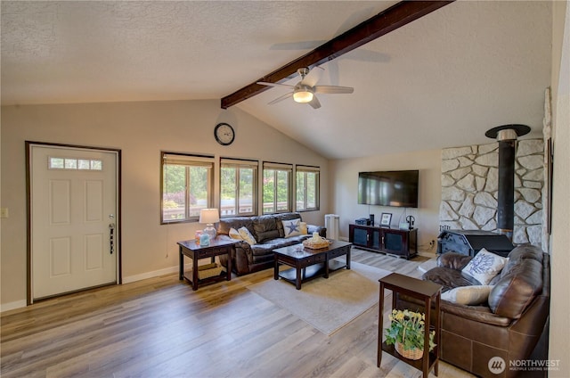 27521 U St, Ocean Park, WA 98640 - living area featuring light wood-type flooring, a ceiling fan, a wood stove, a textured ceiling, and radiator heating unit