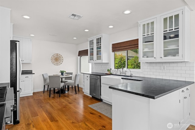 1424 E 36th Ln, Bellingham, WA 98226 - kitchen featuring appliances with stainless steel finishes, dark countertops, white cabinets, a peninsula, and recessed lighting