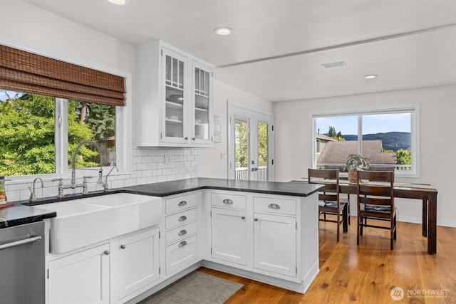 1424 E 36th Ln, Bellingham, WA 98226 - kitchen with stainless steel dishwasher, a peninsula, white cabinetry, recessed lighting, and light wood-style floors
