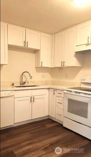 402 4th St SE, Auburn, WA 98002 - kitchen featuring white appliances, under cabinet range hood, white cabinetry, and light countertops