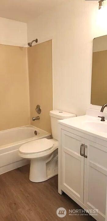 402 4th St SE, Auburn, WA 98002 - full bath with vanity, wood finished floors, and shower / bathtub combination