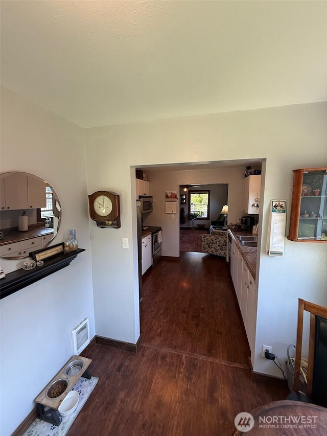 416 Cedar St S, Omak, WA 98841 - kitchen with dark wood-type flooring, stainless steel microwave, and healthy amount of natural light
