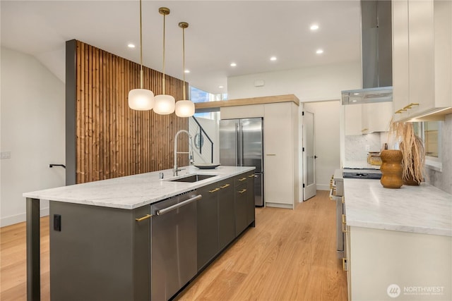 4615 2nd Ave NE, Seattle, WA 98105 - kitchen with appliances with stainless steel finishes, wall chimney range hood, a center island with sink, light wood-style floors, and recessed lighting