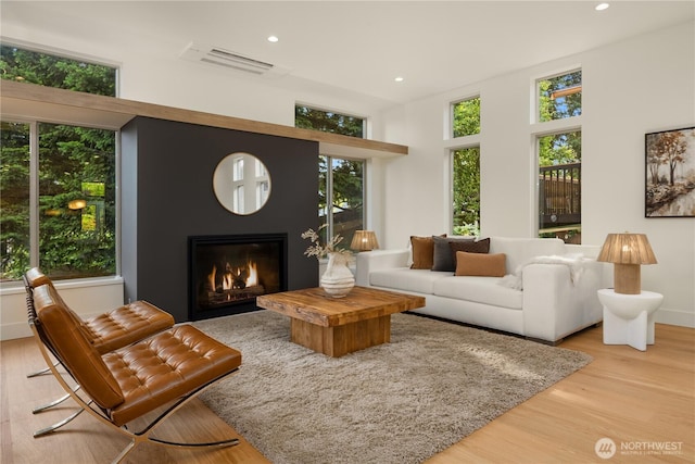 4615 2nd Ave NE, Seattle, WA 98105 - living area featuring wood finished floors, a glass covered fireplace, and recessed lighting