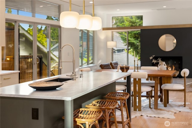 4615 2nd Ave NE, Seattle, WA 98105 - kitchen featuring healthy amount of natural light, light wood-style flooring, a kitchen breakfast bar, hanging light fixtures, and recessed lighting