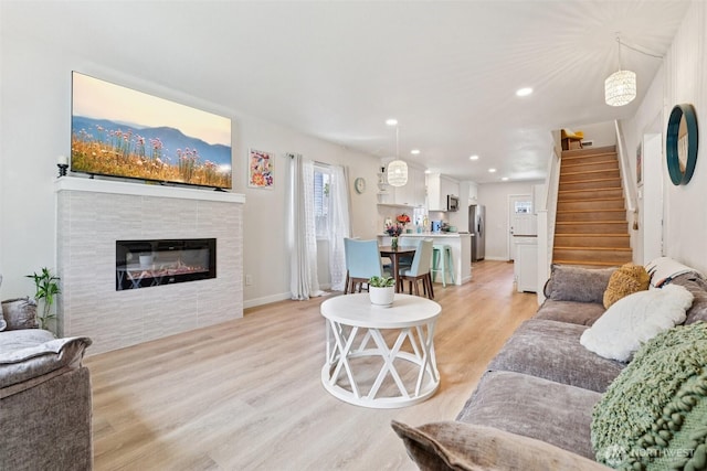 3628 S Sheridan Ave, Tacoma, WA 98418 - living room with light wood-style flooring, stairs, a tiled fireplace, and recessed lighting