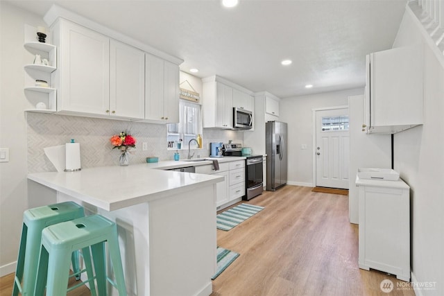 3628 S Sheridan Ave, Tacoma, WA 98418 - kitchen featuring appliances with stainless steel finishes, decorative backsplash, a peninsula, white cabinetry, and recessed lighting