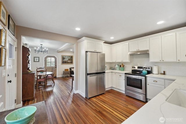 8038 S Ainsworth Ave, Tacoma, WA 98408 - kitchen featuring stainless steel appliances, dark wood finished floors, under cabinet range hood, white cabinets, and light stone counters