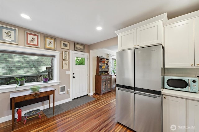 8038 S Ainsworth Ave, Tacoma, WA 98408 - kitchen featuring freestanding refrigerator, wood finished floors, white cabinetry, backsplash, and recessed lighting