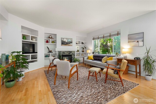 6703 Marshall Ave SE, Auburn, WA 98092 - living room featuring a tiled fireplace, wood finished floors, and built in shelves