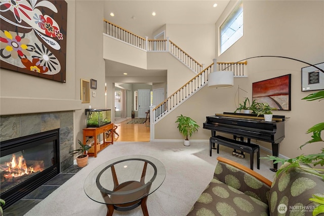 6703 Marshall Ave SE, Auburn, WA 98092 - carpeted living area featuring stairway, a tiled fireplace, a high ceiling, and recessed lighting