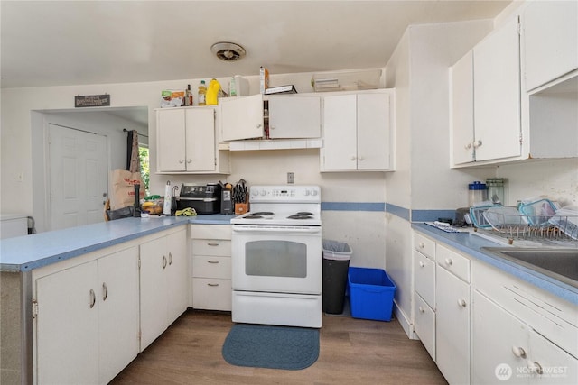 5221 S I St, Tacoma, WA 98408 - kitchen featuring electric stove, light wood-style floors, a peninsula, and white cabinetry
