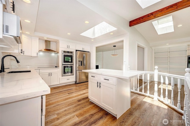 19807 80th Pl W, Edmonds, WA 98026 - kitchen featuring a skylight, appliances with stainless steel finishes, wall chimney range hood, light wood-type flooring, and recessed lighting