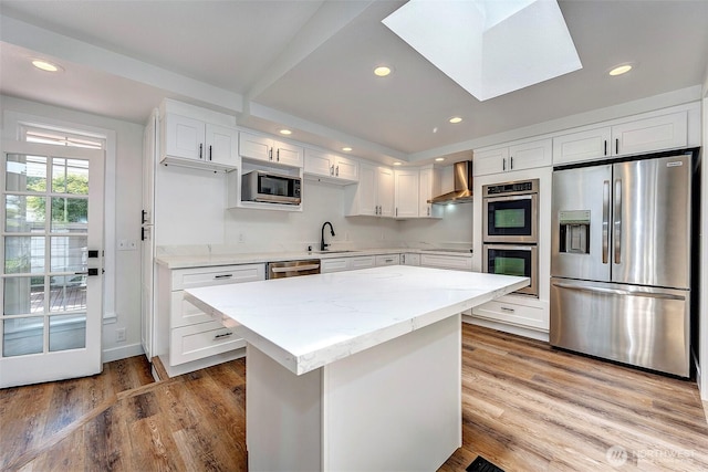 19807 80th Pl W, Edmonds, WA 98026 - kitchen with stainless steel appliances, wall chimney exhaust hood, recessed lighting, light wood-style flooring, and white cabinets