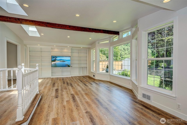 19807 80th Pl W, Edmonds, WA 98026 - unfurnished living room with a skylight, healthy amount of natural light, light wood-type flooring, built in shelves, and recessed lighting