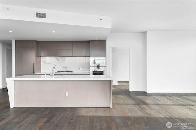 188 Bellevue Way NE Unit 1907, Bellevue, WA 98004 - kitchen with modern cabinets, dark wood-style floors, light countertops, dark brown cabinetry, and decorative backsplash