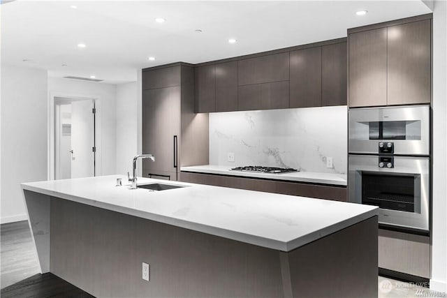 188 Bellevue Way NE Unit 1907, Bellevue, WA 98004 - kitchen with a center island with sink, gas cooktop, modern cabinets, recessed lighting, and light wood-style flooring