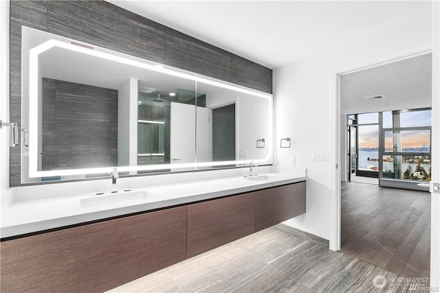 188 Bellevue Way NE Unit 1907, Bellevue, WA 98004 - bathroom featuring double vanity, wood finished floors, and a shower