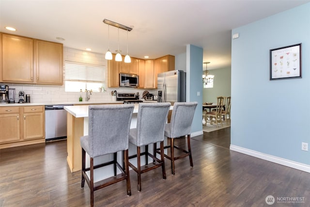 1194 Swan Loop, Dupont, WA 98327 - kitchen with appliances with stainless steel finishes, a kitchen breakfast bar, dark wood-style floors, light brown cabinets, and recessed lighting