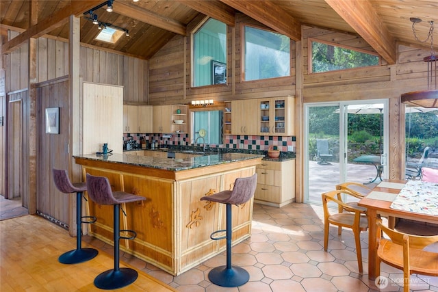 1585 Channel Rd, Lopez Island, WA 98261 - kitchen featuring a wooden ceiling with exposed beams, wood walls, high vaulted ceiling, tasteful backsplash, and a breakfast bar