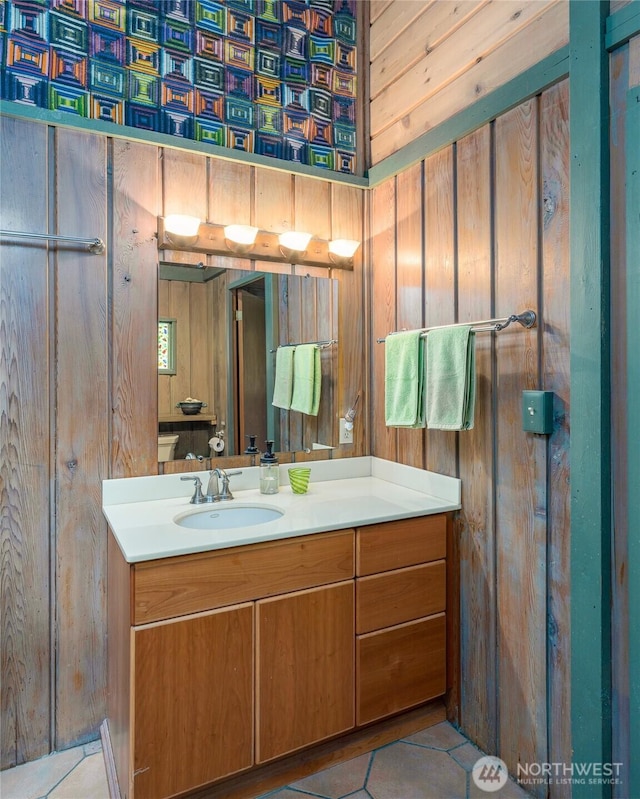 1585 Channel Rd, Lopez Island, WA 98261 - bathroom featuring vanity, tile patterned flooring, wallpapered walls, and wooden walls