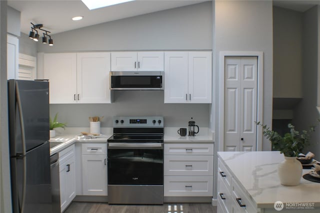 1514 51st Pl SW, Everett, WA 98203 - kitchen with stainless steel appliances, white cabinets, dark wood finished floors, light stone counters, and vaulted ceiling