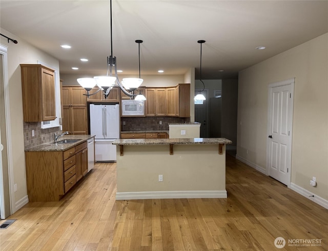 2605 Fir Crest Blvd, Anacortes, WA 98221 - kitchen with white appliances, backsplash, stone counters, a breakfast bar, and recessed lighting