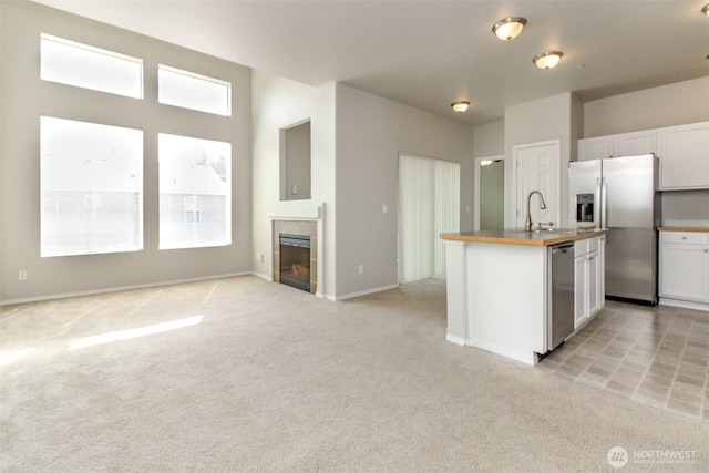 2630 Hamilton Ave, Dupont, WA 98327 - kitchen featuring stainless steel appliances, light colored carpet, plenty of natural light, and white cabinetry