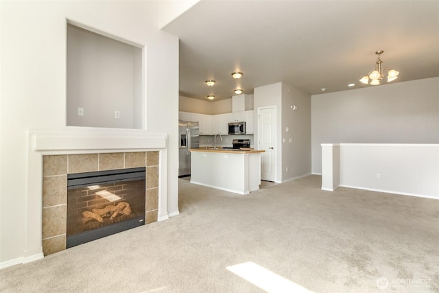 2630 Hamilton Ave, Dupont, WA 98327 - unfurnished living room featuring light carpet, a chandelier, and a tile fireplace
