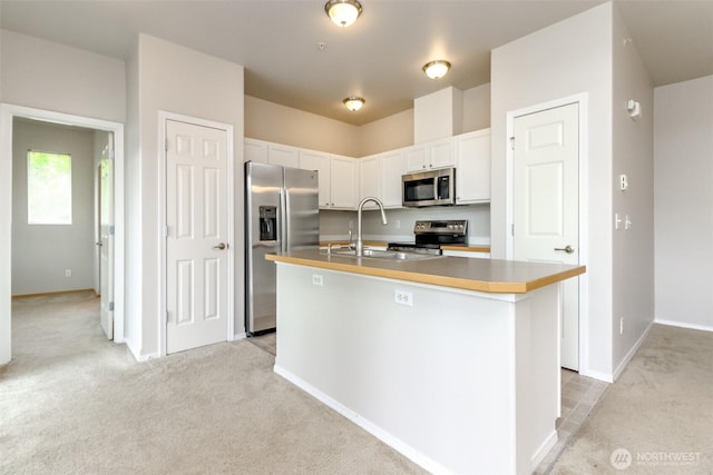 2630 Hamilton Ave, Dupont, WA 98327 - kitchen featuring stainless steel appliances, light colored carpet, an island with sink, and white cabinetry