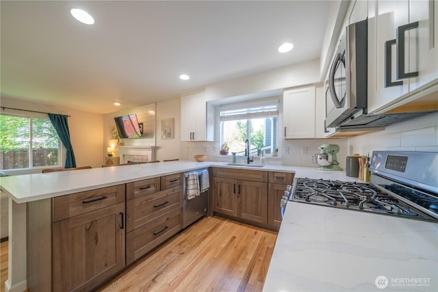 16955 Lookout Mountain Rd SE, Monroe, WA 98272 - kitchen with appliances with stainless steel finishes, a peninsula, healthy amount of natural light, light wood-style floors, and recessed lighting