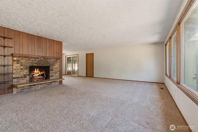 7331 Ridgemont Dr SE, Olympia, WA 98513 - unfurnished living room with a textured ceiling, light carpet, a brick fireplace, plenty of natural light, and wooden walls