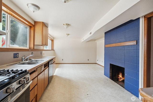 7331 Ridgemont Dr SE, Olympia, WA 98513 - kitchen with appliances with stainless steel finishes, a fireplace, light countertops, and light flooring