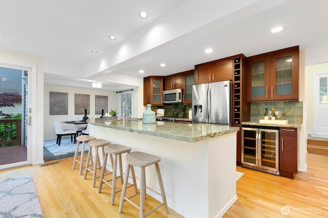 11404 NE 103rd St, Kirkland, WA 98033 - kitchen with wine cooler, appliances with stainless steel finishes, recessed lighting, light wood-type flooring, and backsplash