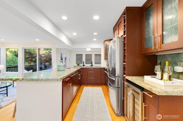11404 NE 103rd St, Kirkland, WA 98033 - kitchen with stainless steel appliances, light wood-style flooring, a peninsula, beverage cooler, and recessed lighting