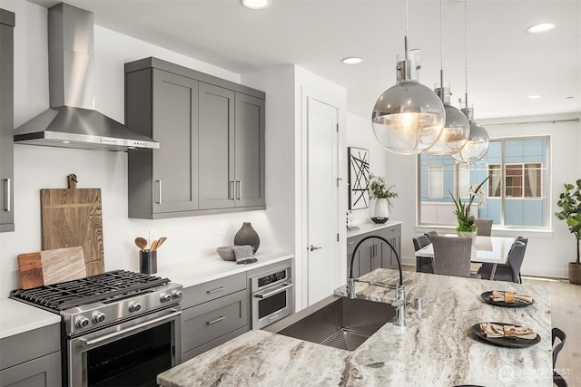 11530 117th Ln NE Unit 2, Kirkland, WA 98034 - kitchen featuring wall chimney exhaust hood, stainless steel appliances, gray cabinets, light stone counters, and recessed lighting