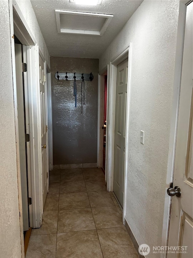 438 Biggs Dr, Moses Lake, WA 98837 - hall with attic access, a textured wall, and light tile patterned floors