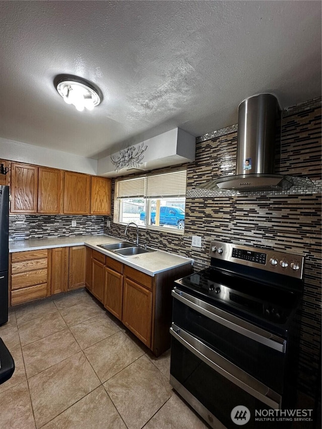 438 Biggs Dr, Moses Lake, WA 98837 - kitchen with electric range, backsplash, wall chimney exhaust hood, freestanding refrigerator, and brown cabinetry